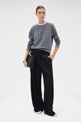 Profile view of model wearing the Oroton Flat Front Pant in Black and 100% wool fabric for Women .