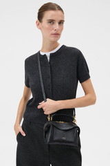 Profile view of model wearing the Oroton Mica Texture Mini Bowler in Black Snake and Premium textured leather for Women .