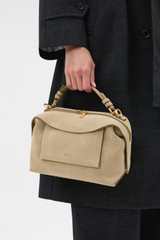 Profile view of model wearing the Oroton Mica Suede Bowler in Caper and Premium suede leather for Women .