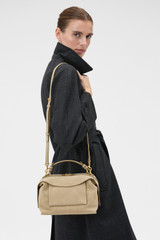Profile view of model wearing the Oroton Mica Suede Bowler in Caper and Premium suede leather for Women .
