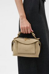 Profile view of model wearing the Oroton Mica Suede Mini Bowler in Caper and Premium suede leather for Women .