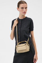 Profile view of model wearing the Oroton Mica Suede Mini Bowler in Caper and Premium suede leather for Women .