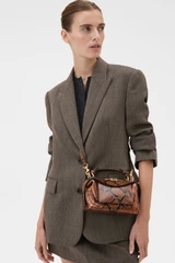 Profile view of model wearing the Oroton Mica Mini Bowler in Copper Snake and Premium textured leather for Women .