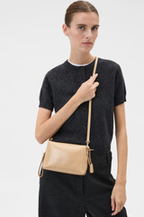 Profile view of model wearing the Oroton Breeze Crackle Camera Bag in Pale Camel and Premium smooth leather for Women .