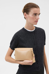 Profile view of model wearing the Oroton Breeze Crackle Camera Bag in Pale Camel and Premium smooth leather for Women .