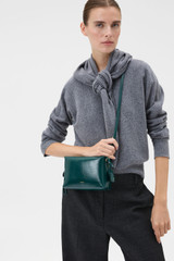 Profile view of model wearing the Oroton Breeze Crackle Camera Bag in Emerald and Premium smooth leather for Women .
