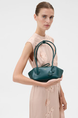 Profile view of model wearing the Oroton Breeze Crackle Baguette in Emerald and Premium smooth leather for Women .
