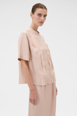 Profile view of model wearing the Oroton Ribbon Trim Top in Rose Tint and 100% silk twill fabric for Women .