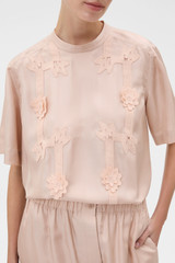 Profile view of model wearing the Oroton Ribbon Trim Top in Rose Tint and 100% silk twill fabric for Women .