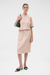 Profile view of model wearing the Oroton Silk Trouser Skirt in Rose Tint and 100% silk twill fabric for Women .