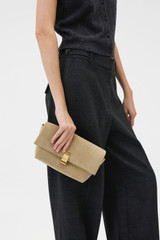 Profile view of model wearing the Oroton Etta Suede Medium Clutch in Caper and Premium suede leather for Women .