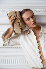Profile view of model wearing the Oroton Etta Suede Medium Clutch in Caper and Premium suede leather for Women .