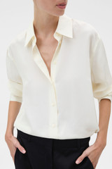 Profile view of model wearing the Oroton Long Sleeve Shirt in Soft Cream and 100% silk habotai fabric for Women .