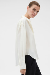 Profile view of model wearing the Oroton Long Sleeve Shirt in Soft Cream and 100% silk habotai fabric for Women .