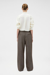 Profile view of model wearing the Oroton Herringbone Pleat Pant in Nutmeg and 100% wool fabric for Women .