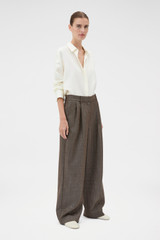 Profile view of model wearing the Oroton Herringbone Pleat Pant in Nutmeg and 100% wool fabric for Women .