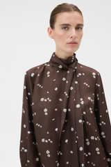 Profile view of model wearing the Oroton Mini Daisy Tie Neck Tunic in Milk Chocolate and 100% silk twill fabric for Women .