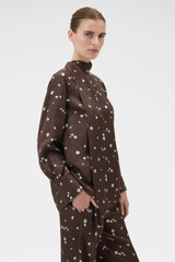 Profile view of model wearing the Oroton Mini Daisy Tie Neck Tunic in Milk Chocolate and 100% silk twill fabric for Women .