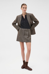 Profile view of model wearing the Oroton Herringbone Mini Skirt in Nutmeg and 100% wool fabric for Women .