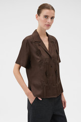 Profile view of model wearing the Oroton Ribbon Trim Camp Shirt in Dark Chocolate and 100% silk twill fabric for Women .