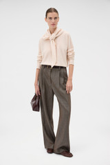 Profile view of model wearing the Oroton Scarf Knit in Rose Tint and 100% mid-gauge Merino wool fabric for Women .