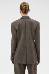 Profile view of model wearing the Oroton Herringbone Shaped Blazer in Nutmeg and 100% wool fabric for Women .