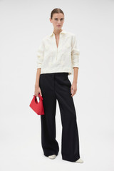 Profile view of model wearing the Oroton Ribbon Trim Shirt in Fresh Cream and 100% midweight linen fabric for Women .