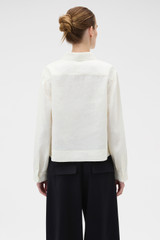 Profile view of model wearing the Oroton Ribbon Trim Shirt in Fresh Cream and 100% midweight linen fabric for Women .