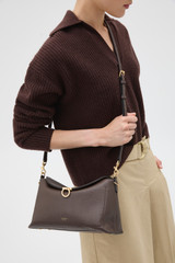Profile view of model wearing the Oroton Yvonne Bowler Bag in Coffee Bean and Premium pebble leather for Women .