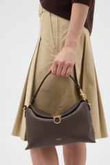 Profile view of model wearing the Oroton Yvonne Bowler Bag in Coffee Bean and Premium pebble leather for Women .