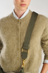 Profile view of model wearing the Oroton Heather Long Light Gold Webbing Strap in Cactus and 100% polyester material for Women .
