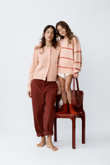Profile view of model wearing the Oroton Knit Detail Cardigan in Peach and 100% superfine wool fabric for Women .