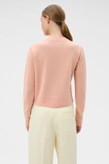 Profile view of model wearing the Oroton Knit Detail Cardigan in Peach and 100% superfine wool fabric for Women .