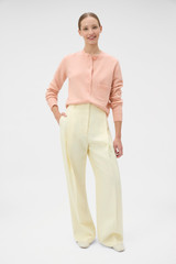 Profile view of model wearing the Oroton Knit Detail Cardigan in Peach and 100% superfine wool fabric for Women .