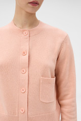 Profile view of model wearing the Oroton Knit Detail Cardigan in Peach and 100% superfine wool fabric for Women .