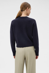 Profile view of model wearing the Oroton Knit Detail Cardigan in North Sea and 100% superfine wool fabric for Women .