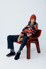 Profile view of model wearing the Oroton Rugby Stripe Knit in North Sea and 100% superfine wool fabric for Women .