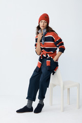 Profile view of model wearing the Oroton Rugby Stripe Knit in North Sea and 100% superfine wool fabric for Women .