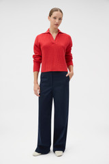Profile view of model wearing the Oroton Rib Knit Popover in Soft Red and 100% superfine wool fabric for Women .