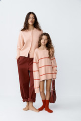 Profile view of model wearing the Oroton Stripe Knit Pullover in Peach and 100% superfine wool fabric for Women .
