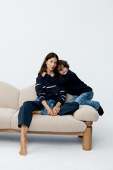 Profile view of model wearing the Oroton Stripe Knit Pullover in North Sea and 100% superfine wool fabric for Women .