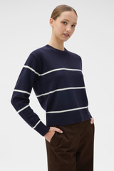 Profile view of model wearing the Oroton Stripe Knit Pullover in North Sea and 100% superfine wool fabric for Women .
