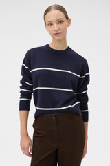 Profile view of model wearing the Oroton Stripe Knit Pullover in North Sea and 100% superfine wool fabric for Women .