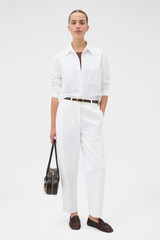 Profile view of model wearing the Oroton Oxford Cropped Shirt in Antique White and 100% cotton fabric for Women .