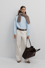 Profile view of model wearing the Oroton Oxford Cropped Shirt in Soft Blue and 100% cotton fabric for Women .