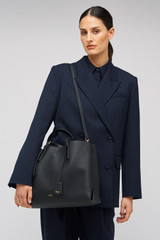 Profile view of model wearing the Oroton Margot Large Day Bag in Black and Premium pebble leather for Women .