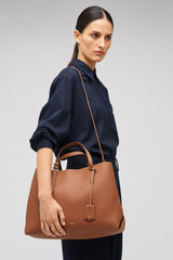 Profile view of model wearing the Oroton Margot Large Day Bag in Whiskey and Pebble leather for Women .