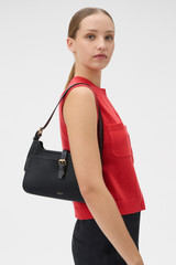 Profile view of model wearing the Oroton Dylan Baguette in Black and Pebble Leather for Women .