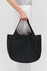 Profile view of model wearing the Oroton Emilia Large Tote in Black and Premium pebble leather for Women .