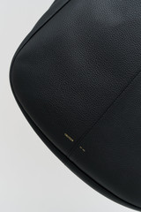 Profile view of model wearing the Oroton Emilia Large Tote in Black and Premium pebble leather for Women .